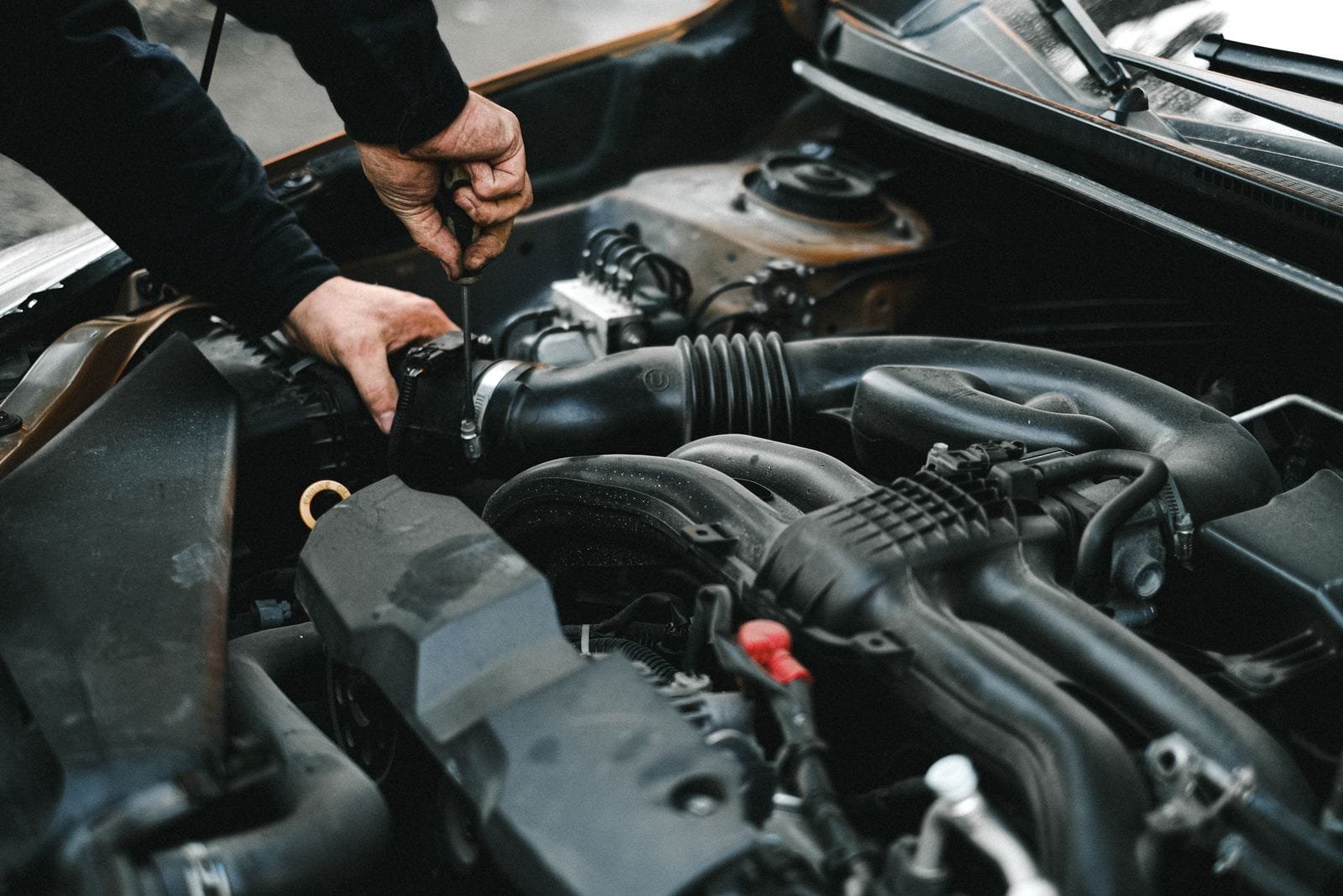 Mechanic inspecting the air intake area of a car engine