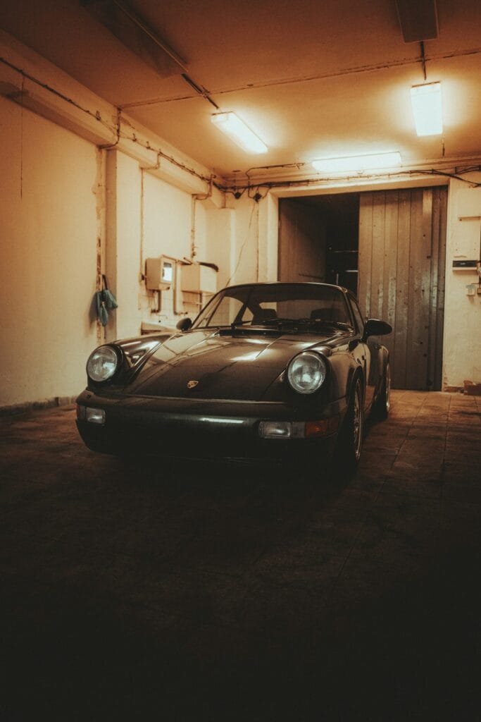 Black Porsche 911 parked indoors in a garage